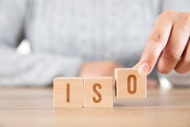 Female hand Wooden blocks with the word ISO quality standart. International organization for standardization.